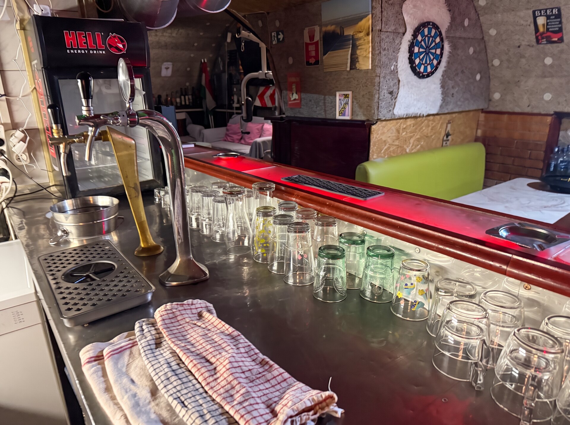 Private bar with beer taps, glassware and a dartboard