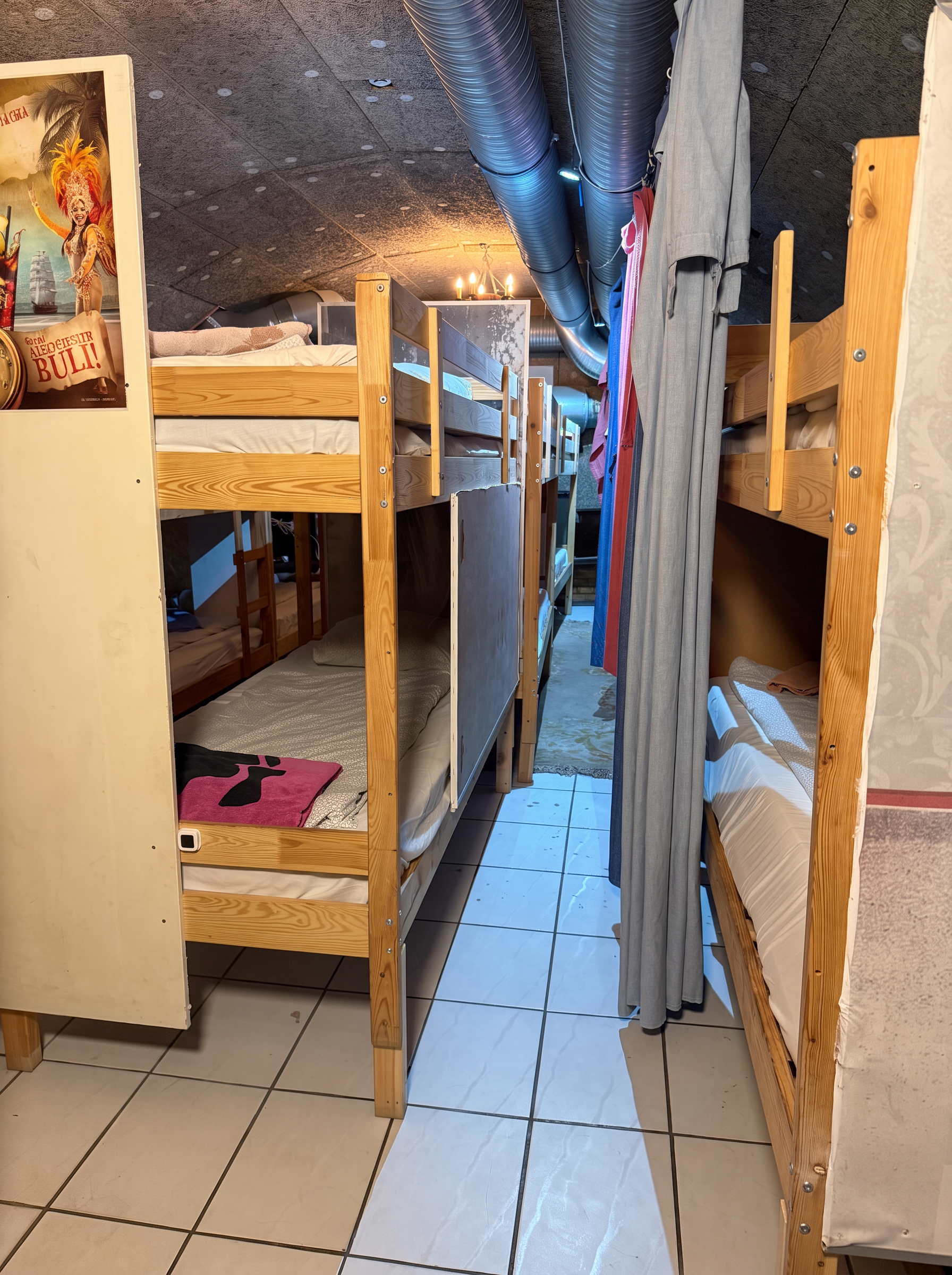 Bunk-bed aisle with tiled floor and privacy curtains